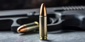 Close-up of a bullet and handgun, showcasing detail and precision in firearms and ammunition.
