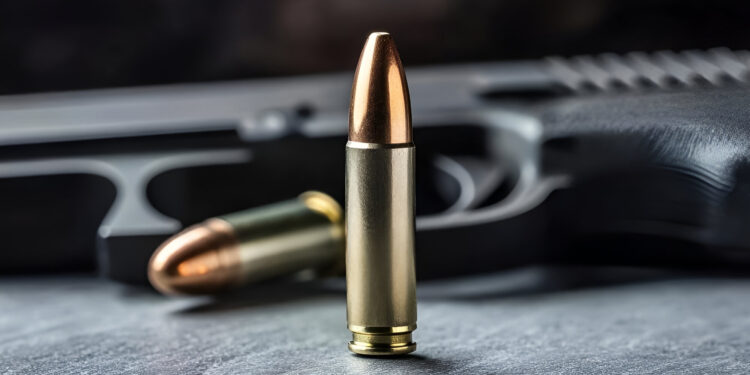 Close-up of a bullet and handgun, showcasing detail and precision in firearms and ammunition.