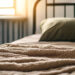 Homeless shelter concept,cozy bedroom features a soft blanket draped over bed and a plush pillow resting on top,illuminated by warm sunlight from window