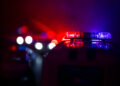 Police car chasing a car at night with fog background.