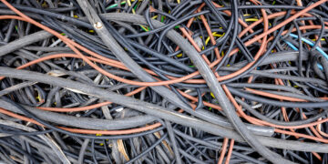 Remains of plastic electrical cables abandoned in a field by thieves.