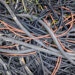 Remains of plastic electrical cables abandoned in a field by thieves.