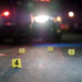 Shell casings are marked with evidence tags at a crime scene
