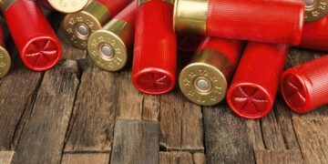 red hunting cartridges for shotgun on wooden background. Macro shot