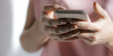 Midsection of woman using smartphone