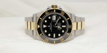 daniel-hay-O703kpzIsQI-unsplash-a black and gold rolex watch on a white background