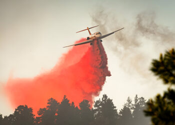 A large air tanker drops red fire retardant on wildfire