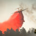A large air tanker drops red fire retardant on wildfire