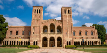 Exterior of Royce Hall building in the campus of UCLA with cloudy sky in the background during sunny day