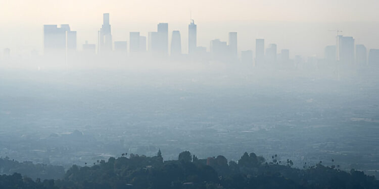 Thick layer of smog and haze from nearby brush fire obscuring the view of downtown Los Angeles buildings in Southern California