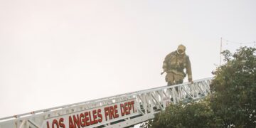a man from LAFD in uniform walking across a bridge