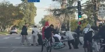 A group of 20 to 30 young bicyclists are seen assaulting a man during a confrontation (Image from LAPD Video)