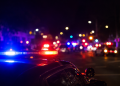Blurred police lights at night following a deadly street takeover shooting in Carson.