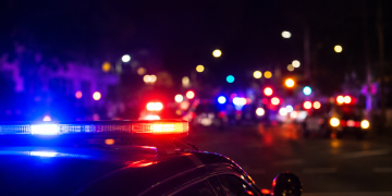 Blurred police lights at night following a deadly street takeover shooting in Carson.