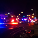 Blurred police lights at night following a deadly street takeover shooting in Carson.