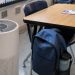 Close-up of a classroom air purifier beside a desk and backpack.