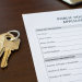 Close-up of apartment keys beside a public housing application form on a desk.