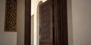 Close-up of mosque prayer rugs and a security camera near an entrance with no identifiable signage.