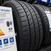 Close-up of new passenger vehicle tires on display beside an energy-efficiency information sheet.