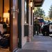 Big Bear hotel room investigation with an open hotel doorway, scattered personal belongings and blurred sheriff's vehicles outside.