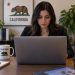 Close-up of a California resident working on a laptop in an office, viewed from the front with the laptop facing away from the viewer, illustrating access to online government services.