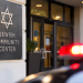 Close-up of a community center entrance with a blurred emergency light in the background, illustrating a reported threat against a Jewish community center.