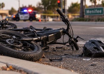 Close-up of a damaged e-bike near a Menifee roadway after a fatal police pursuit crash
