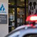 Close-up of an animal shelter entrance with a blurred emergency light in the background, illustrating security concerns after a reported violent attack.