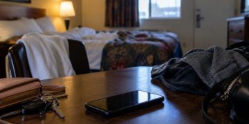 Close-up of an empty Los Angeles motel room with a smartphone, clothing and personal belongings on a table, illustrating a federal sex trafficking case involving minors.