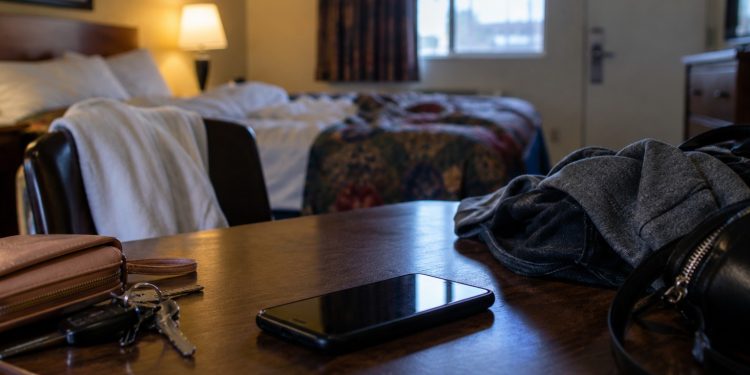 Close-up of an empty Los Angeles motel room with a smartphone, clothing and personal belongings on a table, illustrating a federal sex trafficking case involving minors.