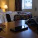 Close-up of an empty Los Angeles motel room with a smartphone, clothing and personal belongings on a table, illustrating a federal sex trafficking case involving minors.