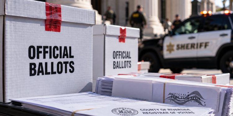 Close-up of sealed election ballot boxes and official election documents near a courthouse, with a blurred sheriff's vehicle in the background, illustrating a ballot custody case.