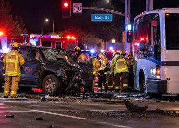 Emergency crews at a Santa Clarita intersection after a pickup truck collided with a bus, with the damaged vehicles and responders visible in the background.