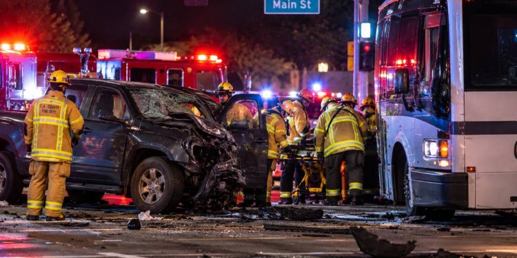 Emergency crews at a Santa Clarita intersection after a pickup truck collided with a bus, with the damaged vehicles and responders visible in the background.