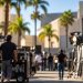 Film production crew working around lighting equipment and equipment carts on a studio backlot, illustrating Hollywood workforce concerns tied to a major merger.