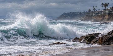Large waves breaking along a Southern California beach under cloudy skies, illustrating powerful swells from Hurricanes Polo and Odalys.