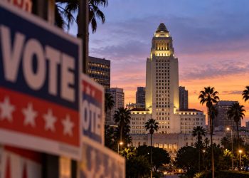 Los Angeles City Hall at dusk with a blurred campaign-style foreground, illustrating the 2026 Los Angeles mayoral race.