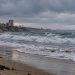 Southern California beach with choppy ocean surf, wet sand and heavy overcast skies, illustrating coastal impacts expected from Hurricane Polo.