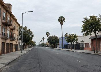 A street in South Los Angeles with older residential buildings and storefronts, photographed in neutral daylight, illustrating neighborhoods where homicides remain concentrated.