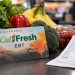 Close-up of a CalFresh EBT card beside fresh groceries and a supermarket receipt, illustrating changes to food assistance benefits in California.