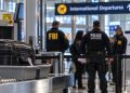 Close-up of an airport security checkpoint and blurred federal agents near an international departure gate, illustrating an alleged foreign-agent investigation at LAX.