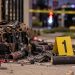 Close-up of damaged pyrotechnic materials and an evidence marker near a residential scene, illustrating an investigation into a fatal South Los Angeles explosion.