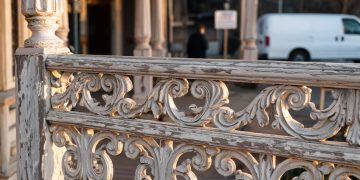 Close-up of ornate Victorian railings with weathered paint, with a blurred entrance behind, illustrating a historic nightclub venue closure.