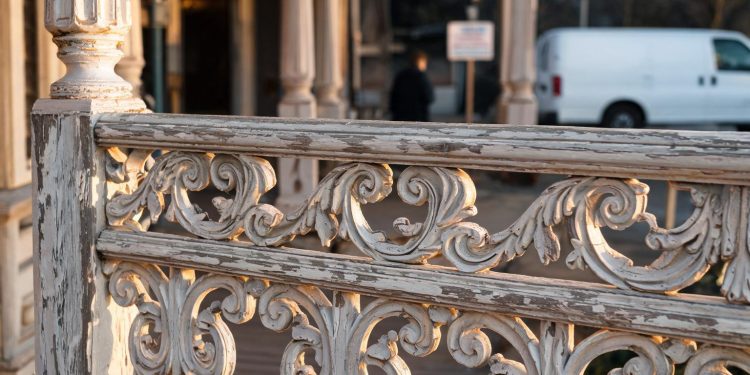 Close-up of ornate Victorian railings with weathered paint, with a blurred entrance behind, illustrating a historic nightclub venue closure.