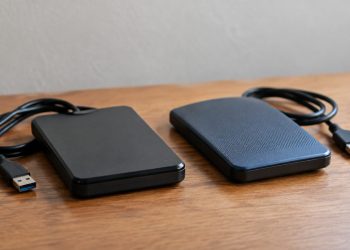 Close-up of two external hard drives side by side on a plain wooden table in soft indoor daylight, illustrating a Ventura County digital evidence case.