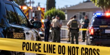 Daytime law enforcement response outside a Cudahy residence, with sheriff’s vehicles, emergency responders and investigators blurred behind police tape.