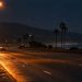 Empty southbound lanes of a freeway at night in Ventura under tall overhead lights, with dark hills in the distance.