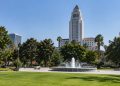 Grand Park in downtown Los Angeles with Los Angeles City Hall rising behind trees and empty paths in afternoon daylight.