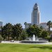 Grand Park in downtown Los Angeles with Los Angeles City Hall rising behind trees and empty paths in afternoon daylight.