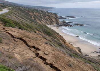 High view of a long crack in a dry coastal hillside below Pacific Coast Highway above Moro Beach near Laguna Beach in neutral daylight.